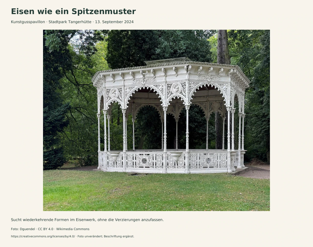 Ein heller, filigraner Pavillon steht vor dunkelgrünen Bäumen. Dünne Säulen tragen gelappte Bögen; Brüstung und oberer Rand sind mit wiederholten Ranken, runden Medaillons und Ziermustern besetzt.