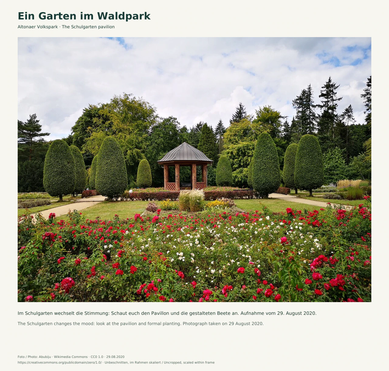 Ein offener Pavillon mit dunklem Spitzdach steht zwischen kegelförmig geschnittenen Gehölzen; davor blühen rote und weiße Blumen, seitlich verlaufen helle Gartenwege.