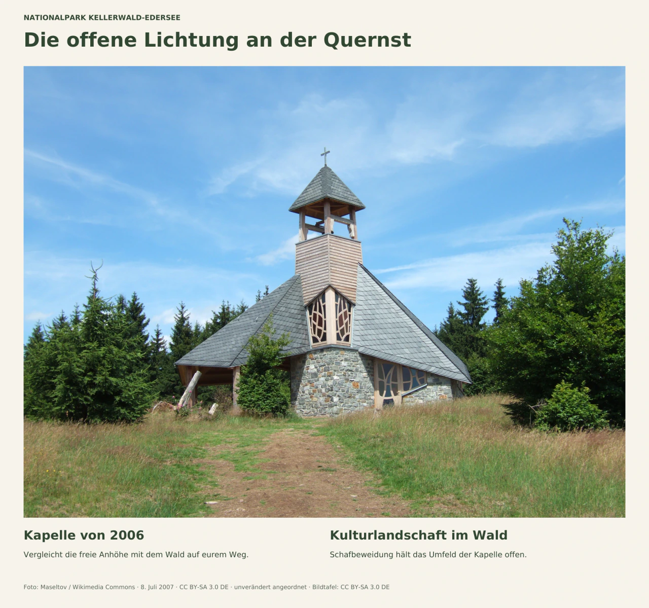 Die Quernst-Kapelle mit weit heruntergezogenem Schieferdach, Holzturm und Steinwänden steht auf einer Grasfläche vor Bäumen. Die Bildtafel nennt das Baujahr 2006 und die Schafbeweidung zur Offenhaltung des Umfelds. Aufnahme von 2007.